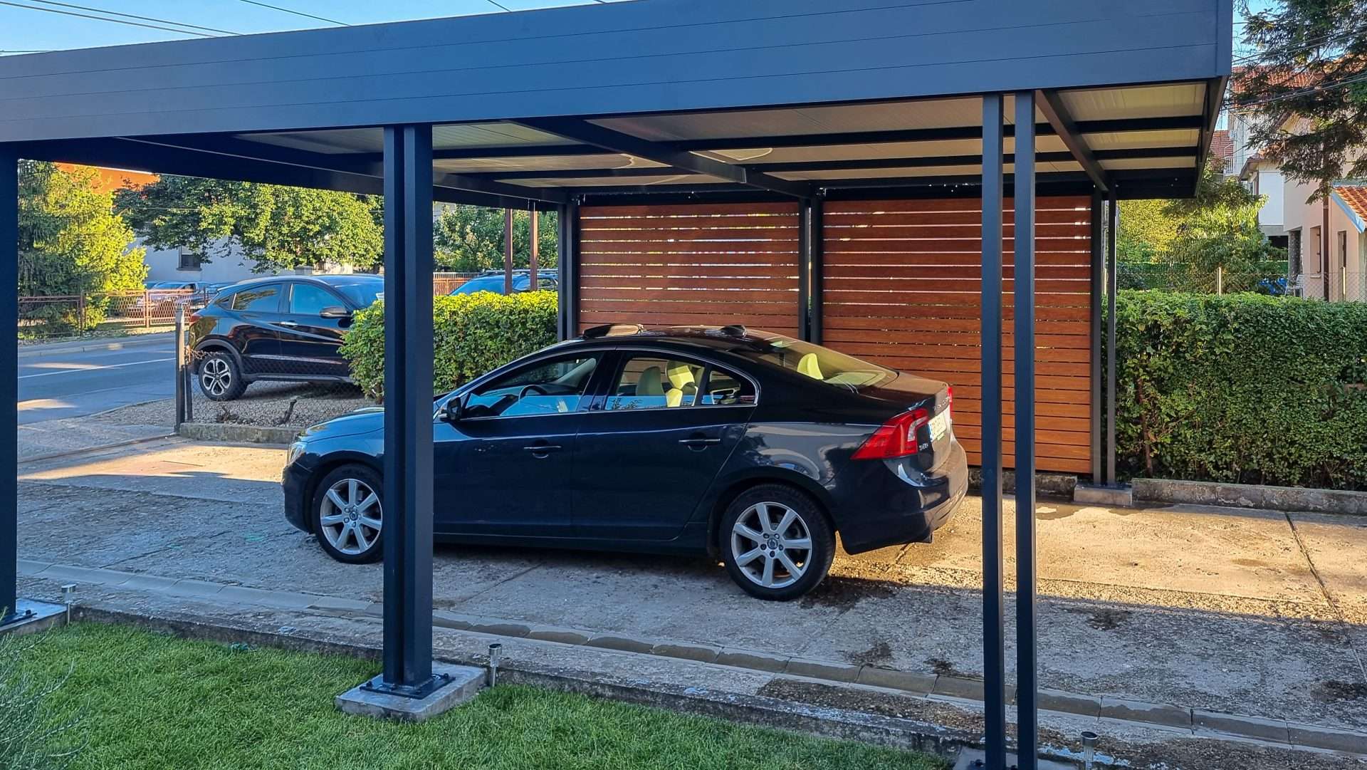 Aluminijumski karport sa crnim profilima i bočnim lamelama u dekoru drveta - nadstrešnica za parkirano vozilo
