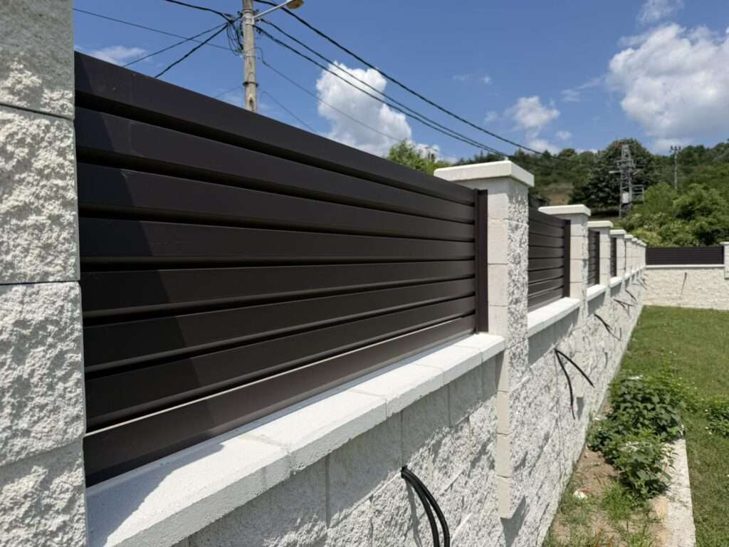Aluminijumska ograda u antracit boji sa kamenim stubovima - pogled u perspektivi